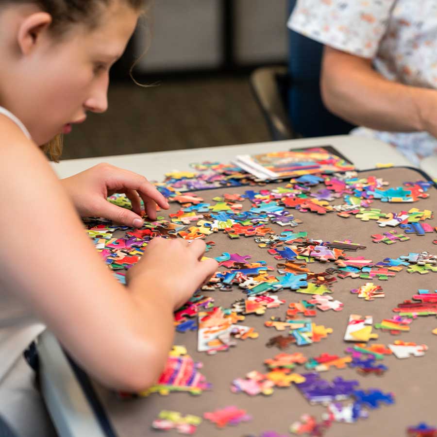 STAR participant putting together a puzzle in the Game Room | STARability Foundation