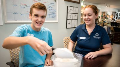 star participant and director of social enterprise measuring wax for hand-poured candles